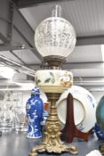 A late 19th to early 20th-century brass oil lamp, featuring a frosted glass globe shade, a hand