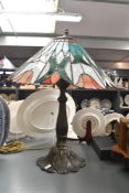A contemporary Tiffany-style Tulip table lamp, featuring a soft orange shade with repeating tulip