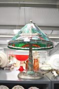 A contemporary Tiffany-style dragonfly table lamp, featuring a green leaded shade with repeating