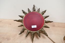 A mid to late 20th-century brass sunburst wall light, having a red glass circular centre, unmarked
