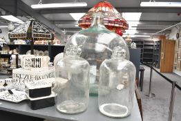 A large late Victorian glass carboy; sold with two 20th-century glass demijohn bottles, all