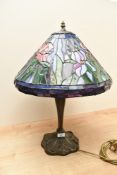 A contemporary Tiffany-style floral table lamp, featuring a colourful leaded shade with repeating