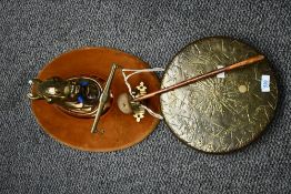 A vintage cast brass hanging dinner gong, suspended from a mounted metal horse head upon deep
