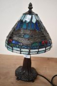 A small contemporary Tiffany-style dragonfly table lamp, featuring a leaded blue and green shade