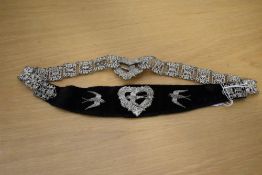 An antique women's decorative waist belt in black velvet and white metal elaborate chain and link