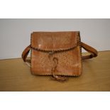 A 20th century vintage tooled leather shoulder bag, in smooth tan with black woven edging,