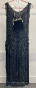 An early 20th century beaded column dress with open sides in sheer black silk chiffon, velvet tabs