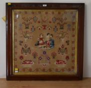 A framed and glazed needlework sampler depicting a man doffing his cap and woman carrying a fruit