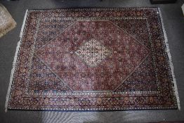 A Persian Bidjar hand knotted wool rug having a central diamond medallion, dusty rose ground, all