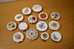A collection of thirteen 1970-1990s gilt compacts featuring white lids with floral designs, mostly