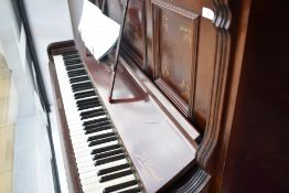 A late 19th or early 20th Century upright piano having overstrung action on metal frame, in mahogany