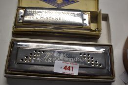 Two boxed Harmonicas. A M Hohner 'the Chromonica' and a Hero Harmonica