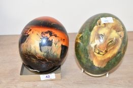 A vintage South African decoupaged ostrich egg, featuring lions and golden star motifs; sold with