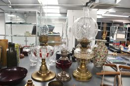 Three Victorian brass oil lamps, to feature a Hinks and Sons of Birmingham cranberry font example, a