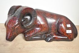 A large contemporary resin recumbent ram sculpture, featuring a dark black and red speckled body,