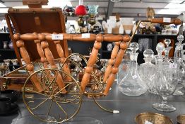 A vintage turned wood and brass magazine rack, of bike-shaped form, unmarked, 60cm in length,