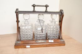 A late 19th to early 20th-century John Grinsell & Sons tantalus, comprising three square-cut crystal