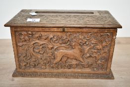A small 20th-century carved wooden tissue box holder, in the form of a chest, featuring detailed