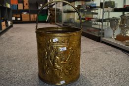 A vintage embossed brass coal bin, of cylindrical form with over handle, galvanised liner and