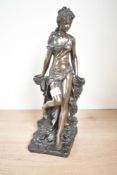 A contemporary Crosa bronze-effect resin female figure, gracefully leaning upon a wall as her