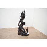 A mid 20th-century Balinese hand carved dark wood sculpture, depicting a female figure upon a swan-
