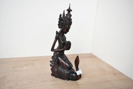 A mid 20th-century Balinese hand carved dark wood sculpture, depicting a female figure upon a swan-