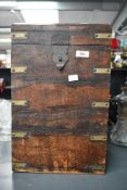 A tall 20th-century hard wood chest, featuring brass and metal hardware and a hinged lid,