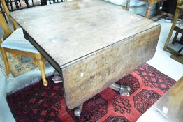 A 19th Century mahogany breakfast table having short drop flaps, frieze drawer and quadruple legs,