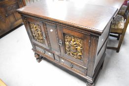 A vintage oak side cabinet by Wood Bros , having carved crests to door panels with two drawers