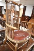 A traditional stained frame spindle and wheel back carver chair having overstuffed leather seat