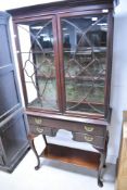 A late 19th or early 20th Century mahogany display cabinet having glazed top over one long and two