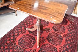 A 19th Century mahogany occasional table having snap top mechanism over turned column and triple