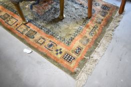 A vintage style fireside rug having green ground and orange patterned border, approx. 150 x 91cm