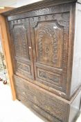 A period oak linen cupboard, having typical extensive carved decoration plus mythical creatures,