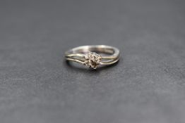 A 9ct white gold four stone diamond ring, in a claw set square mount, missing a stone, with split