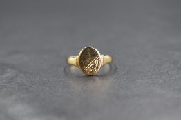A 9ct gold signet ring, the oval panel having scroll decoration to one side, marked 375, ring size
