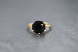 A 9ct gold green sapphire set ring, the round cut sapphire measuring approximately 2.5ct, in a six