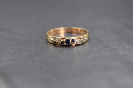 A 9ct gold sapphire and diamond set band, the three graduated round cut sapphires flanked by two