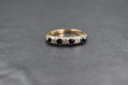 A 9ct gold half eternity ring having four sapphires interspersed by three diamond chips in a claw