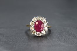 An 18ct gold ruby and diamond cluster ring, the central claw set oval ruby being approx 1.5ct within