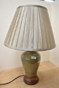 A tall contemporary studio pottery lamp base, of baluster form, featuring an olive green and rust