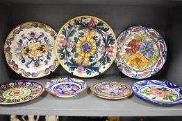A quantity of 20th-century Spanish hand decorated ceramic plates, featuring a selection of