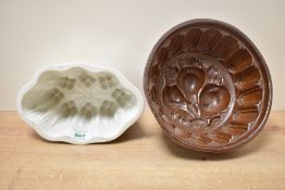 Two late 19th-century to early 20th-century ceramic jelly moulds, to feature a decorative fruit