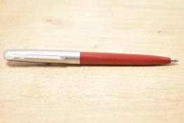 A Parker 61 ballpoint pen in red with lustraloy cap and chrome trim