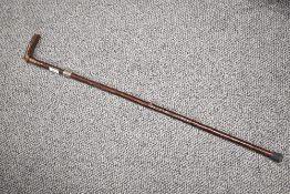 A hazel walking stick measuring 90 cm long with rubber foot and a silver ferule inscribed 'W. Wright