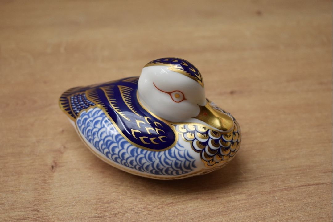 A Royal Crown Derby bone china duck paperweight, having Imari style decoration and a gold coloured - Image 1 of 3