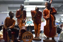 A group of four wooden African American jazz band studies including saxophone, drummer and