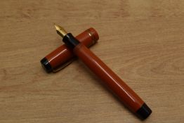 A Parker Duofold Special Streamlined button fill fountain pen in Red with two narrow cap bands
