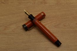 A Parker Duofold Special Streamlined button fill fountain pen in Red with two narrow cap bands