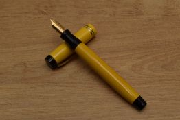 A Parker Duofold Streamline Senior button fill fountain pen in Mandarin Yellow with two narrow bands